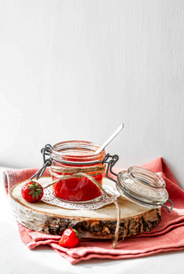 Erdbeermarmelade in einem Marmeladeglas und einer Erdbeere