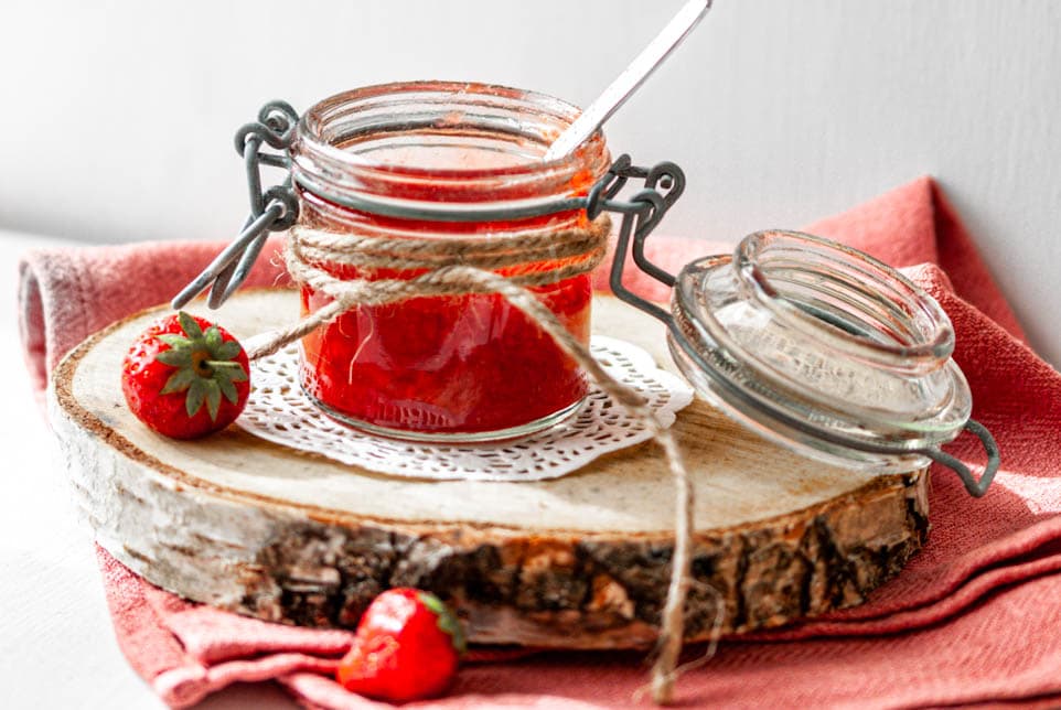 Erdbeermarmelade in einem Marmeladeglas und einer Erdbeere