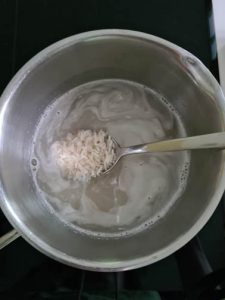 Reis mit Wasser in Kochtopf